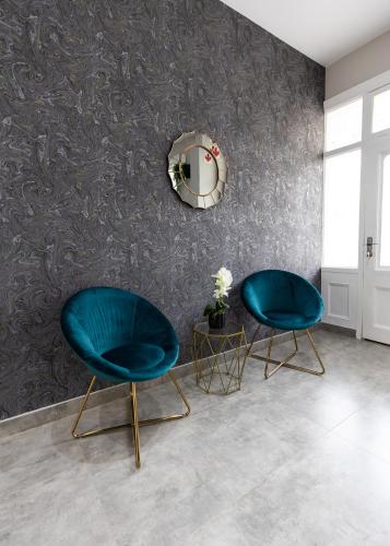 two blue chairs in a room with a mirror at Luxe Suites Boutique Hotel in Durban