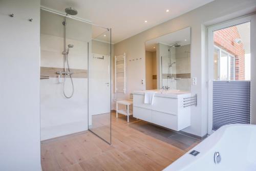 ein Bad mit einer Badewanne, einem Waschbecken und einer Dusche in der Unterkunft Ferienhof Büdlfarm - Wohlfühlhütte - 51650 in Sahrensdorf