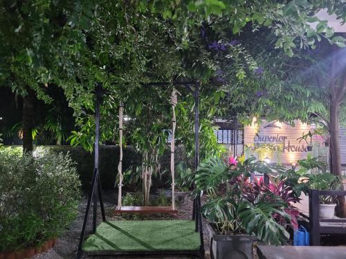 a garden with a swing with trees and plants at Superior House Khaoyai in Ban Khanong Phra Klang (1)