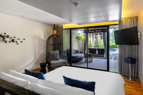 a bedroom with a large white bed and a tv at Cross Chiang Mai Riverside in Chiang Mai
