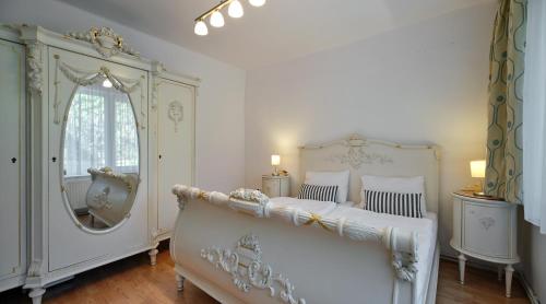 a bedroom with two beds and a large mirror at Fövenyes House Grande in Balatonudvari