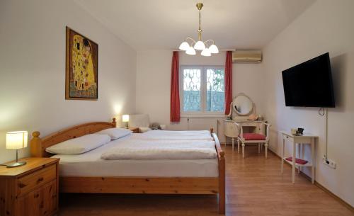 1 dormitorio con 1 cama grande y TV en Fövenyes House Grande en Balatonudvari