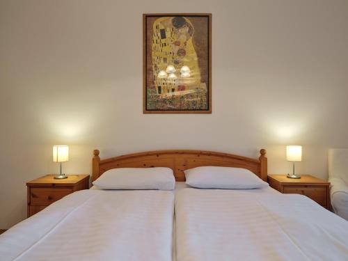a bedroom with two beds with white sheets and two lamps at Fövenyes House Grande in Balatonudvari