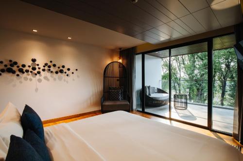 a bedroom with a bed and a large window at Cross Chiang Mai Riverside in Chiang Mai