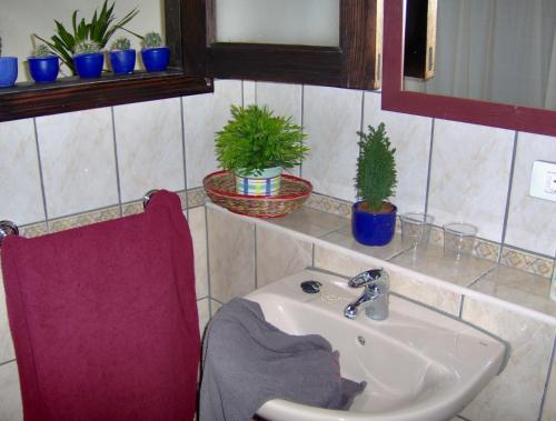 baño con lavabo y silla roja en Kleines Einzelzimmer mit Meerblick, en Icod de los Vinos