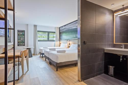 a hotel room with two beds and a sink at Andante Hotel in Barcelona