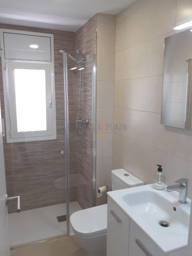 a bathroom with a shower and a toilet and a sink at Apartamentos Dins Mar Apto. 6 in Torredembarra