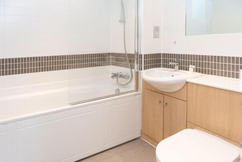 a bathroom with a sink and a tub and a toilet at City Stay Apartments - Vizion in Milton Keynes