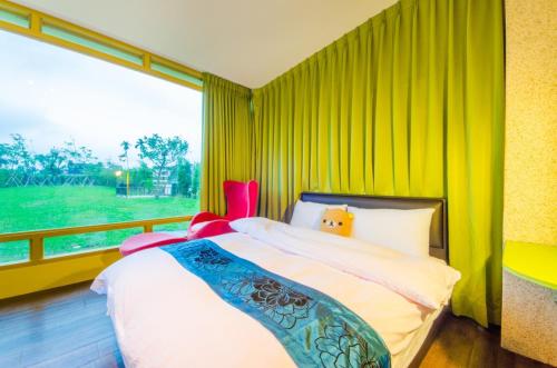 a bedroom with a bed and a large window at 梅花湖-陽光屋民宿 in Dongshan
