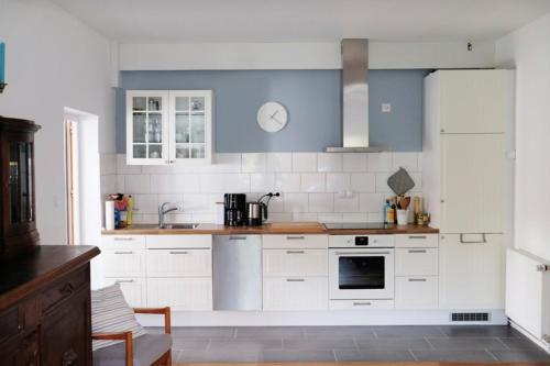 eine Küche mit weißen Schränken und blauen und weißen Fliesen in der Unterkunft Haus Doris - 19549 in Heiligenhafen