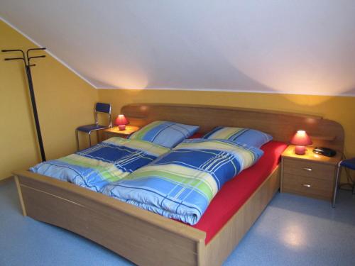 1 dormitorio con 1 cama grande y 2 almohadas en Ferienwohnung Mauer, Wohnung "A", en Heede