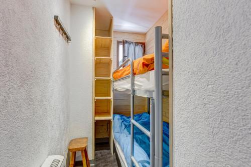 a small room with bunk beds and a chair at Studio Cornaline - Studio aux pieds des pistes in Crest-Voland