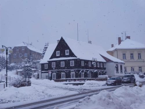 a large house in a snow covered city at Cafe Nostalgie dvoulůžkový romantický pokoj in Krásná Lípa