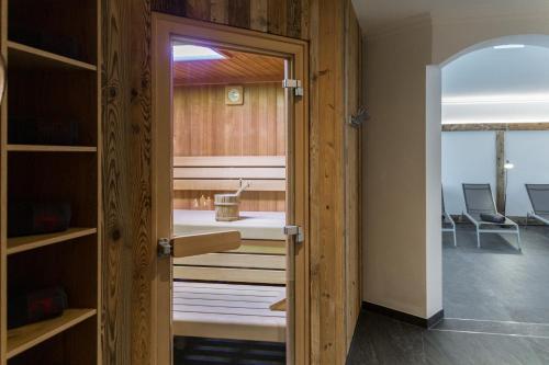 a door to a room with a bed and chairs at Knappensteig Appartements in Wagrain