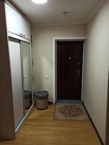 einen Flur mit Tür und Ottomane in einem Zimmer in der Unterkunft Sweet Home in Taschkent