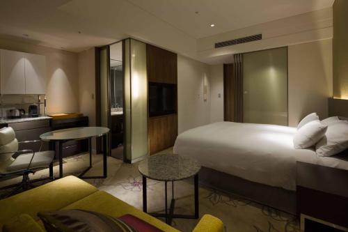 a hotel room with a large bed and a kitchen at Osaka Marriott Miyako Hotel in Osaka