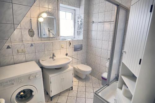 a bathroom with a sink and a washing machine at Kranich VIII, FW 39 in Zingst