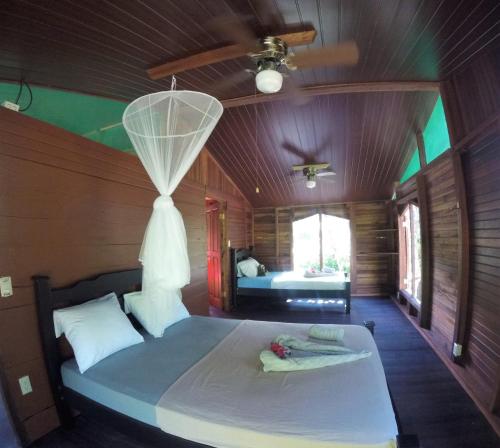 - une chambre avec un grand lit et un plafond dans l'établissement Haus mit trop Garten am Cahuita Nationalpark, à Comadre