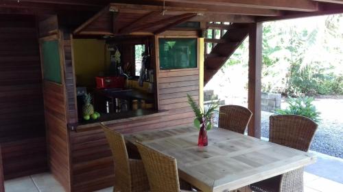 - une table et des chaises sur une terrasse avec une maison dans l'établissement Haus mit trop Garten am Cahuita Nationalpark, à Comadre