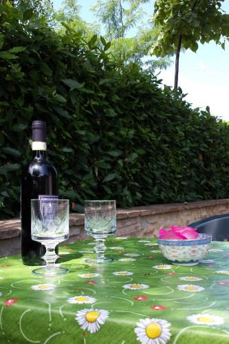 a table with two glasses and a bottle of wine at Agriturismo Villino del Grillo in San Gimignano