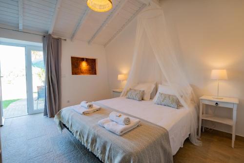 um quarto com uma cama com toalhas em Casas Da Bica - Turismo Espaço Rural em Cercal