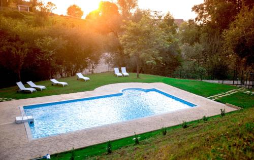 una piscina en un patio con sillas alrededor en Hotel Peñas Blancas en Liaño