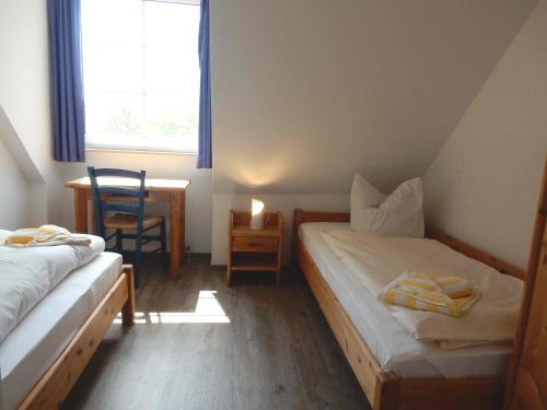プレローにあるResi A7のベッドルーム1室(ベッド2台、テーブル、窓付)