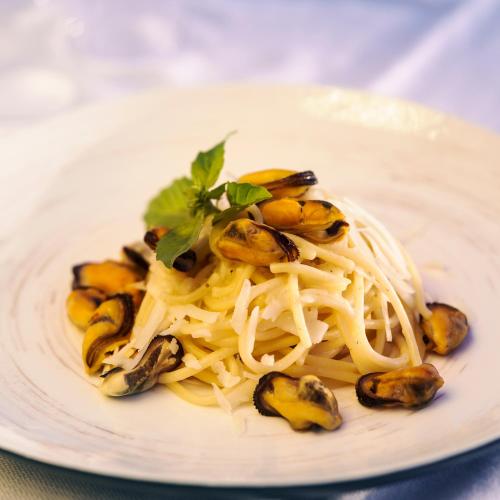 a plate of pasta with mushrooms and a garnishment at Puntaquattroventi in Ercolano