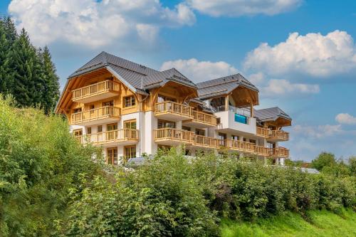a large apartment building with solar panels on it at SCHWARZENBACH - Apartments & Rooftop Pool in Feldberg