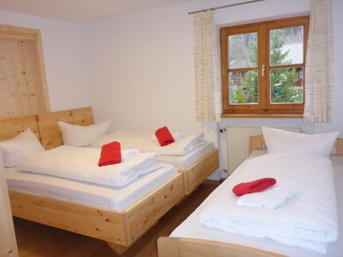two beds in a room with red pillows on them at Ferienwohnung Uferweg in Fischbachau