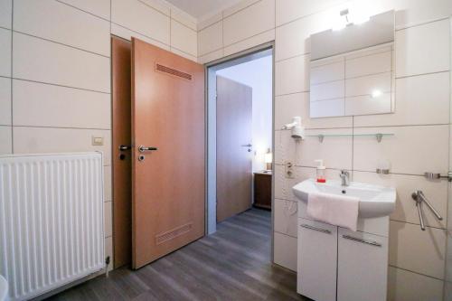 メッペンにあるFamilienhof Brüning - Doppelzimmer Waldesruh Iのバスルーム(シンク、鏡、ドア付)