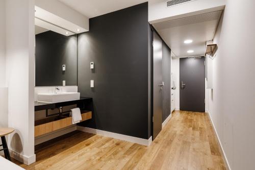 a bathroom with a sink and a mirror at SMARTments business Mannheim Hauptbahnhof in Mannheim