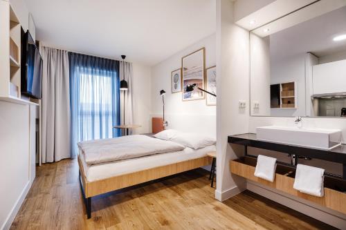 a bedroom with a bed and a sink at SMARTments business Mannheim Hauptbahnhof in Mannheim