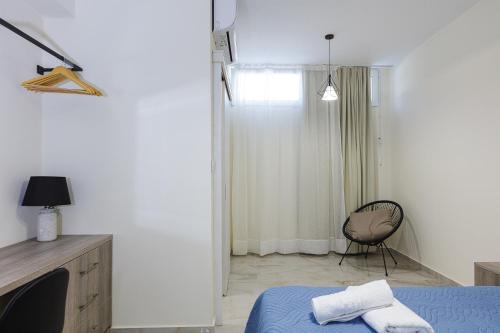 a white room with a bed and a chair at Family Friendly Basilicata Attali villa Private Pool,Children area in Vlikhádha