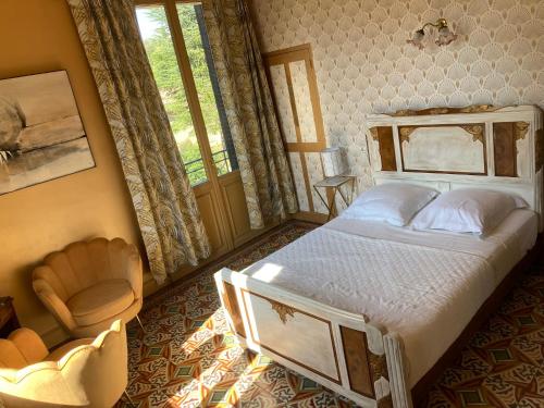 une chambre avec un lit, une chaise et une fenêtre dans l'établissement Chambre d'Hôte La Romaine, à Vaison-la-Romaine