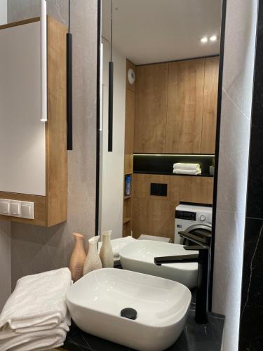 a bathroom with a large white sink on a counter at Family & Business Elegant Apartments Kadzielnia, ul Zgody, Stadion Korona, WDK -1 Bedroom, Terrace, Garage - NEW! in Kielce