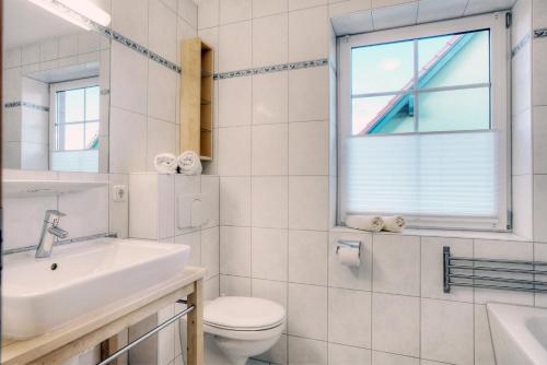 a bathroom with a sink and a toilet and a window at Edda in Zingst