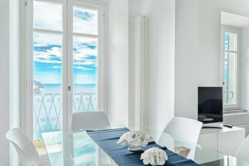 a dining room with a table and a view of the ocean at Salty Sky Flat , Terre Marine in Corniglia