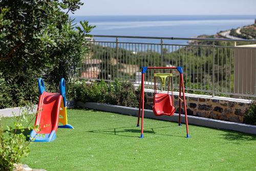 three play equipment in a yard with the ocean in the background at Family Friendly Basilicata Attali villa Private Pool,Children area in Vlikhádha