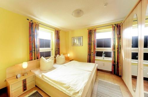 ツィングストにあるOstsee-Residenz, Whg 10のベッドルーム1室(白いベッド1台、窓2つ付)