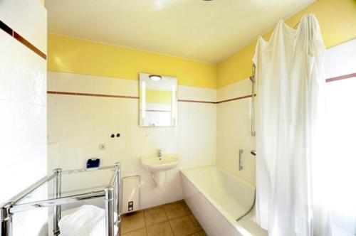 y baño con bañera, aseo y lavamanos. en Ostsee-Residenz, Whg 10 en Zingst