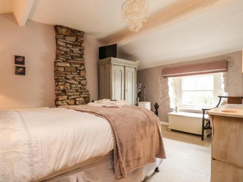 a bedroom with a bed and a stone wall at Duckdown in Clitheroe