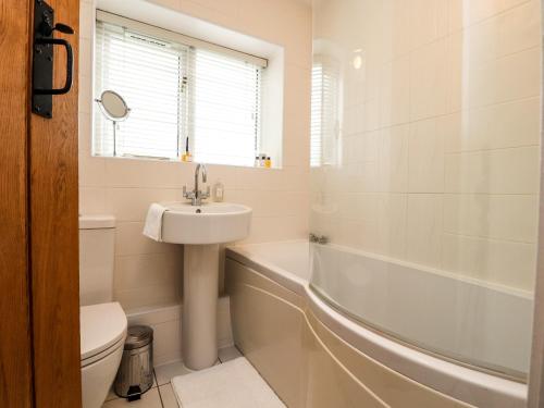 a bathroom with a sink and a tub and a toilet at Duckdown in Clitheroe