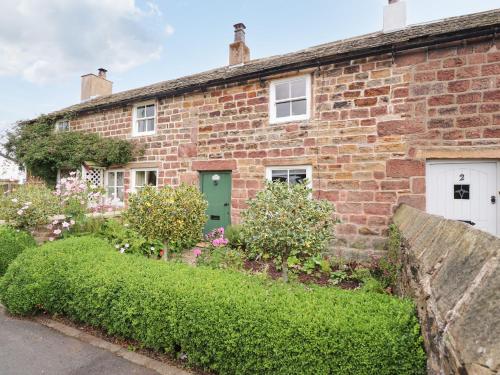 an old brick house with a green door at Duckdown in Clitheroe
