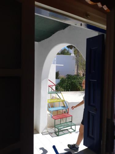a person walking through a door with a colorful chair at Pagali Hotel in Órmos Aiyialís