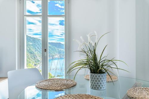 a glass table with two chairs and a potted plant at Sea Breeze Flat, Terre Marine in Corniglia