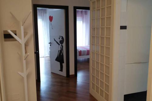 a room with a door with a painting of a woman with a balloon at Casa Riccò di Cinzia e Samuele in Riccò del Golfo di Spezia