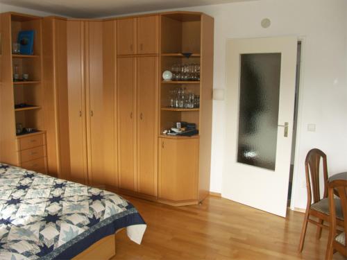 ラドルフツェル・アム・ボーデンゼーにあるFerienwohnung am Kurpark Mettnauのベッドルーム1室(ベッド1台、キャビネット、テーブル付)