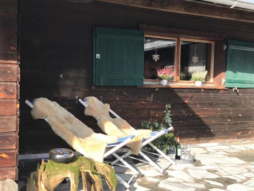 einen Schaukelstuhl vor einem Haus mit einem Fenster in der Unterkunft Haus am Reh in Gargellen