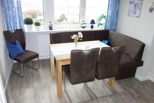 uma sala de jantar com uma mesa e cadeiras e um sofá em "Ostseeblick" L-7-6 em Heiligenhafen